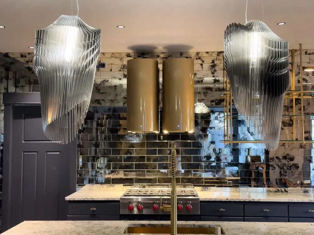 Elegant modern kitchen with stylish pendant lights, glossy tiles, and luxurious marble countertops.