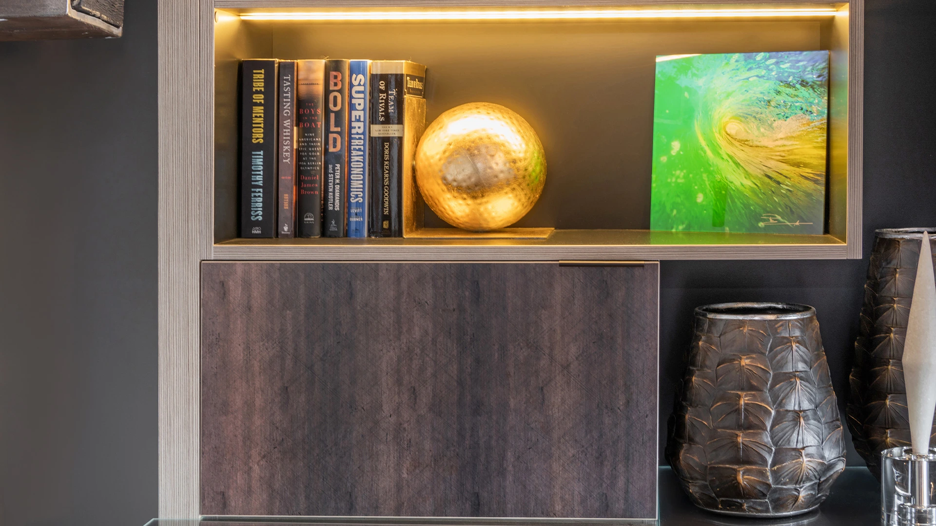 Modern office shelving unit with curated books and decorative accents by Ariana Adireh.