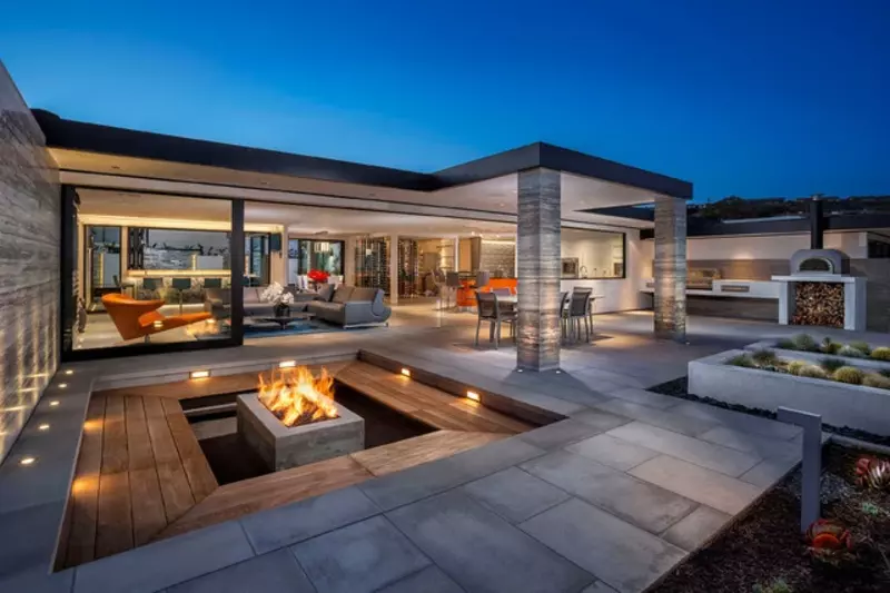 Sophisticated outdoor oasis featuring a modern kitchen and inviting fire pit for gatherings.