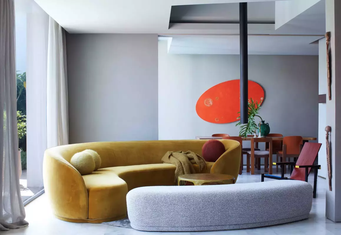 Stylish modern living room featuring a unique yellow sofa and vibrant abstract artwork.