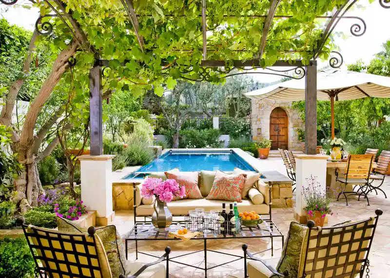 Cozy outdoor oasis with a pool, plush seating, and lush greenery for relaxation.