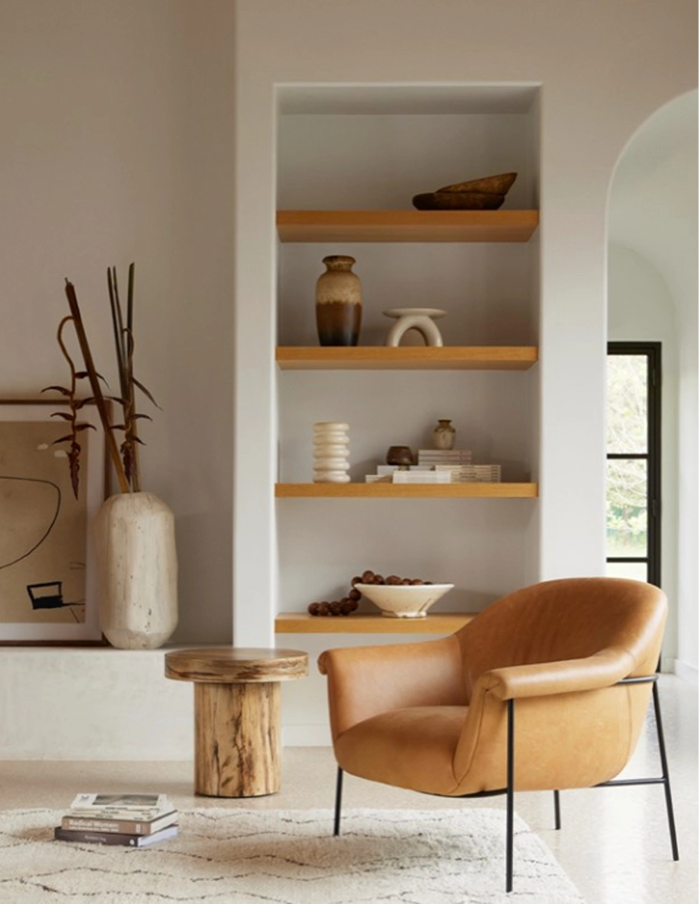 Inviting modern reading nook with a cozy chair, rustic table, and curated decor accents.