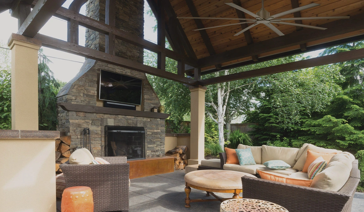 Stylish outdoor living space featuring a cozy patio, fireplace, and lush greenery for relaxation.