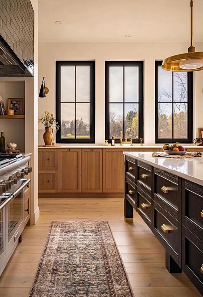 Elegant modern kitchen design featuring a spacious island, rich cabinetry, and abundant natural light.