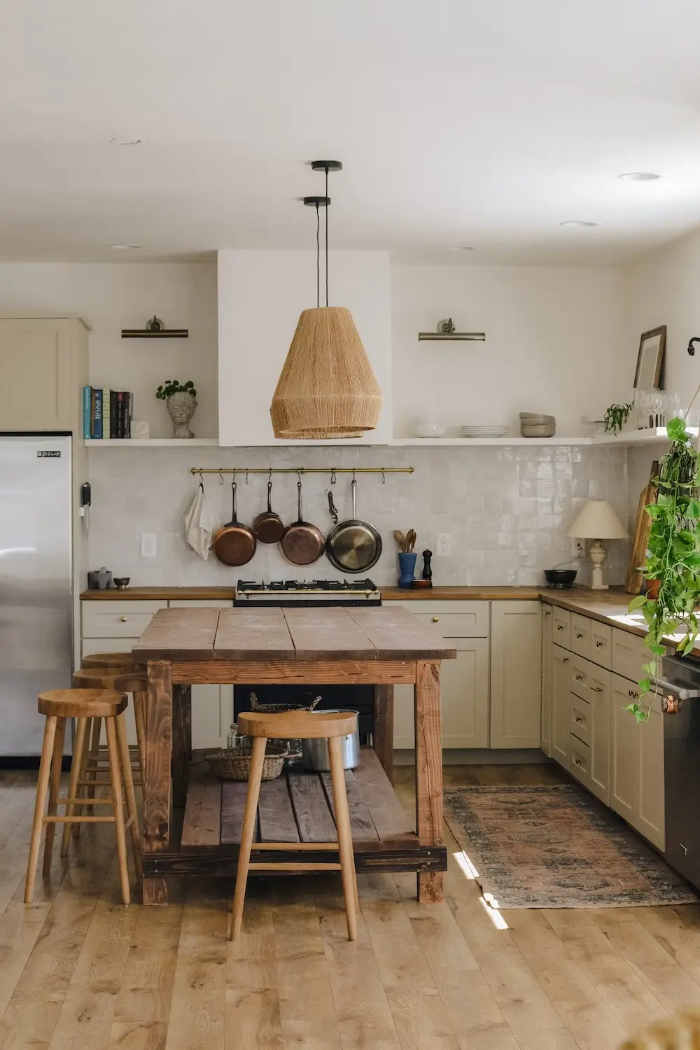 Warm modern kitchen with rustic island, natural light, and stylish decor for entertaining.