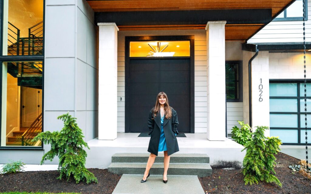 Elegant woman at a stylish modern home entrance with inviting ambiance and contemporary design.