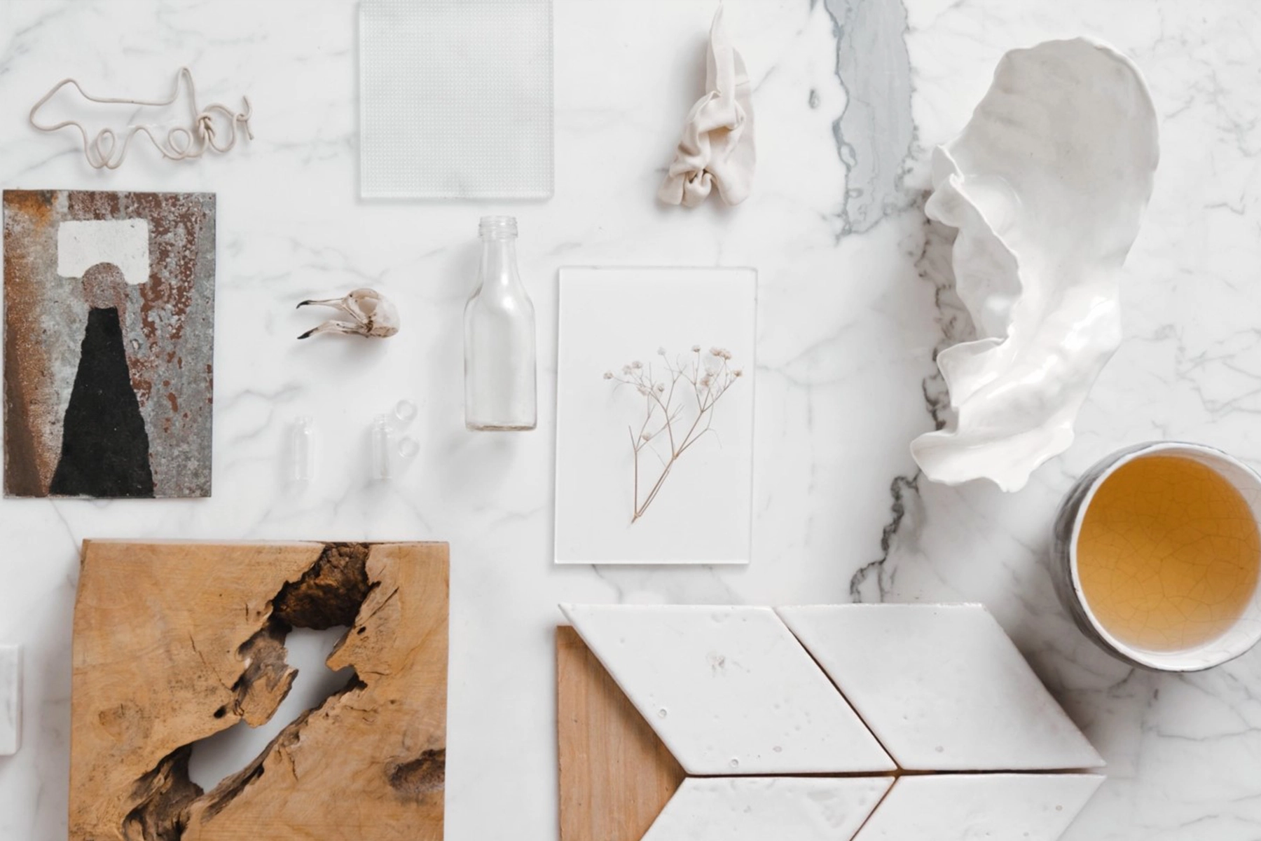 Artistic flat lay featuring nature-inspired objects on marble, blending modern design and nostalgia.