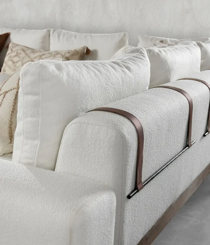 Stylish white sofa with leather straps, blending comfort and modern design in any space.