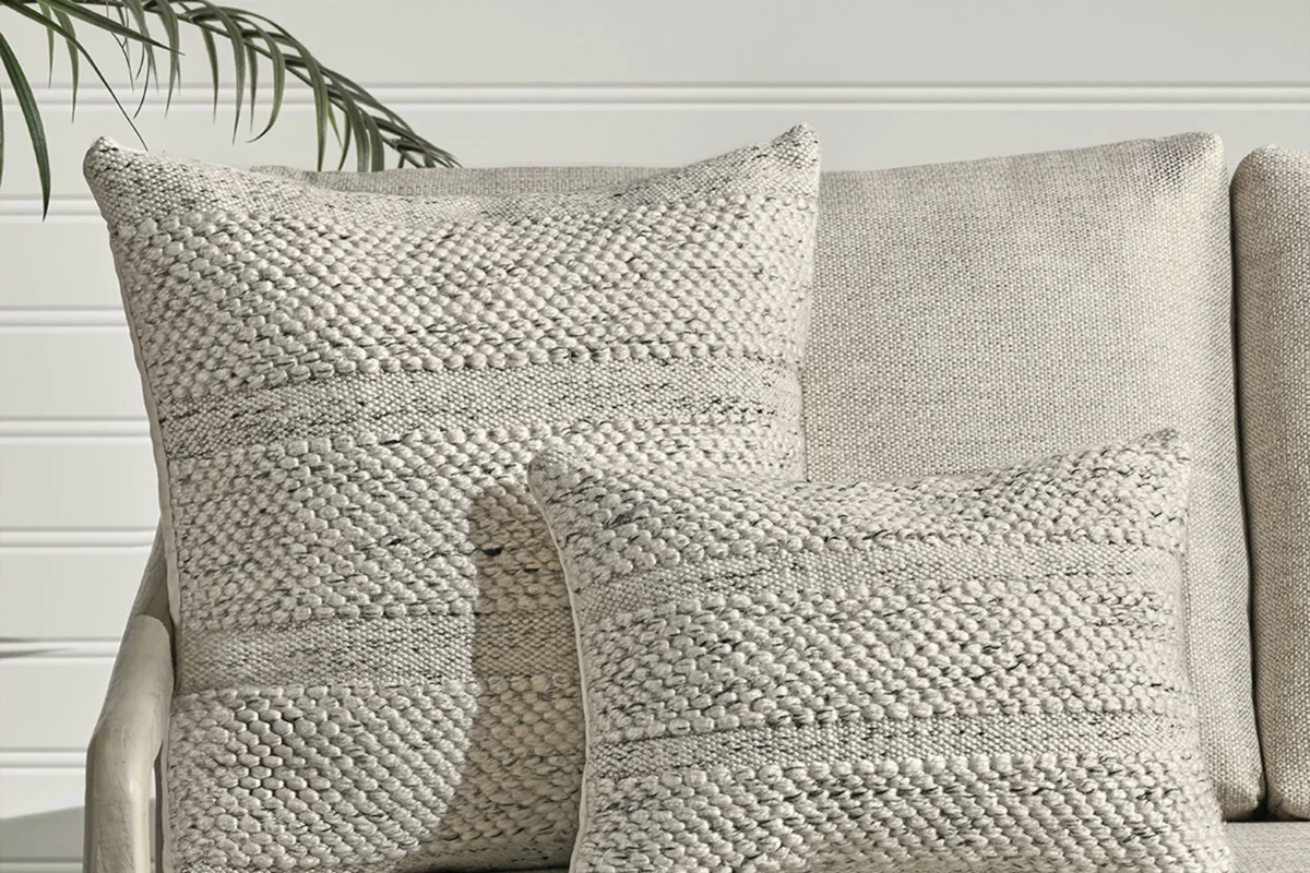 Cozy sofa with stylish decorative pillows in neutral tones and varied textures.