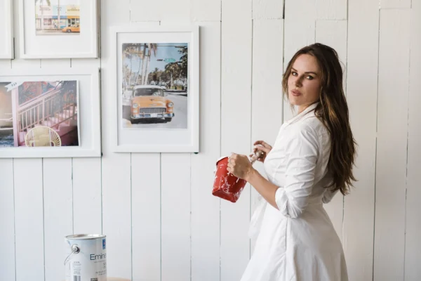 Woman painting in a bright, inviting creative space with vintage decor and warm natural light.