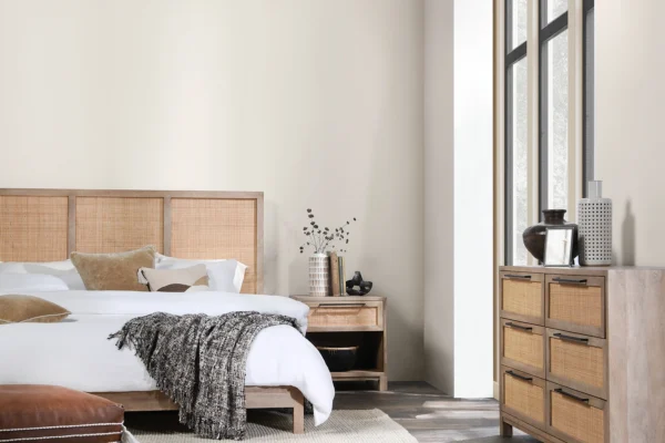 Cozy minimalist bedroom featuring wood and rattan accents for a serene retreat.