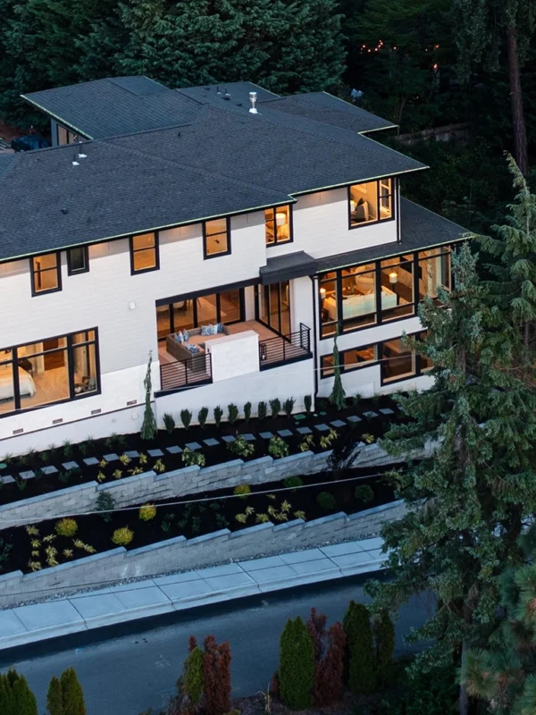 Modern multi-level home with large windows nestled in lush greenery and inviting landscapes.