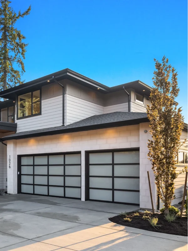 Contemporary two-story home with elegant design, large windows, and beautiful landscaping.