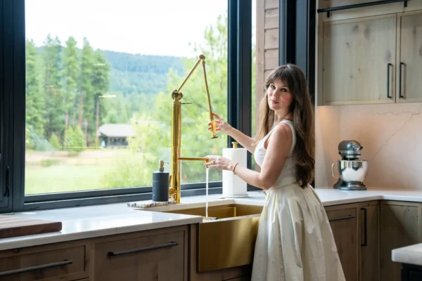 Luxury interior decorator Suncadia mountain home kitchen showcasing custom wood cabinetry, brass fixtures, modern appliances, and elegant styling by Ariana Designs & Interiors luxury design team.