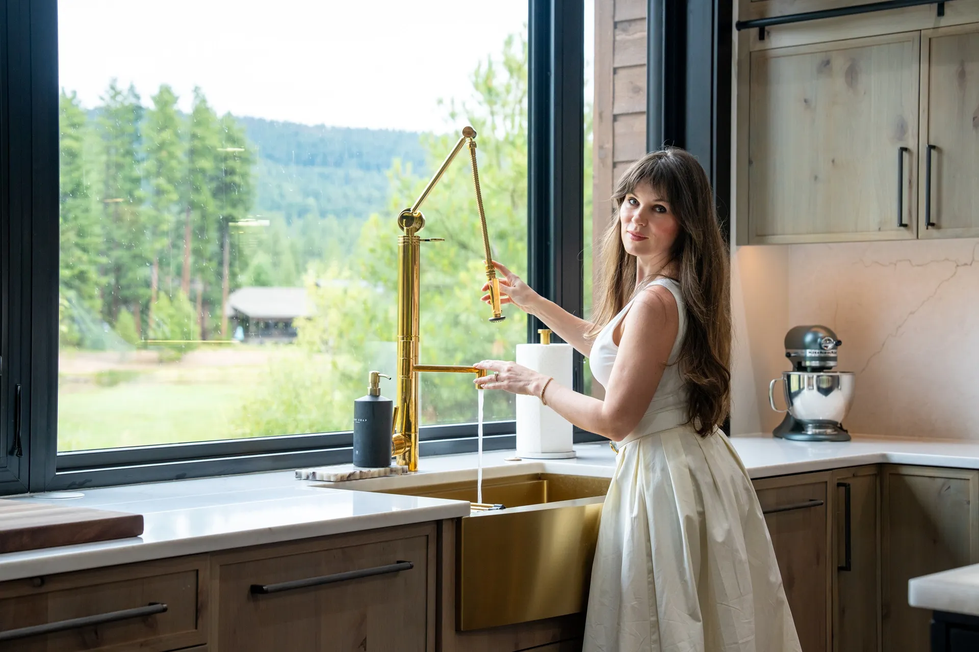 Luxury interior decorator Suncadia mountain home kitchen showcasing custom wood cabinetry, brass fixtures, modern appliances, and elegant styling by Ariana Designs & Interiors luxury design team.
