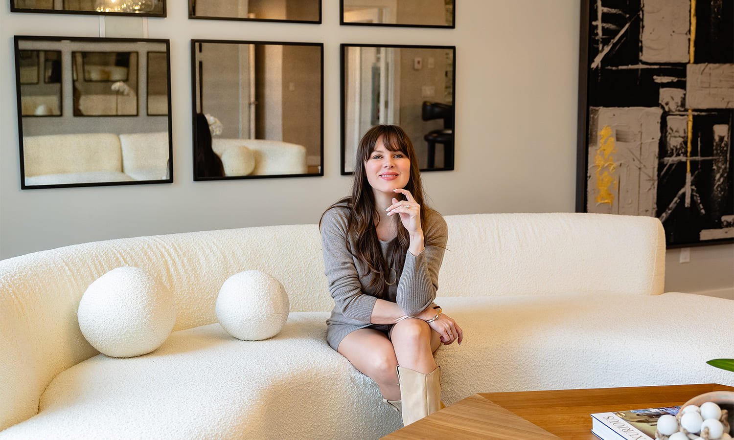 Modern living space with a sculptural sofa and elegant decor featuring a stylish woman.