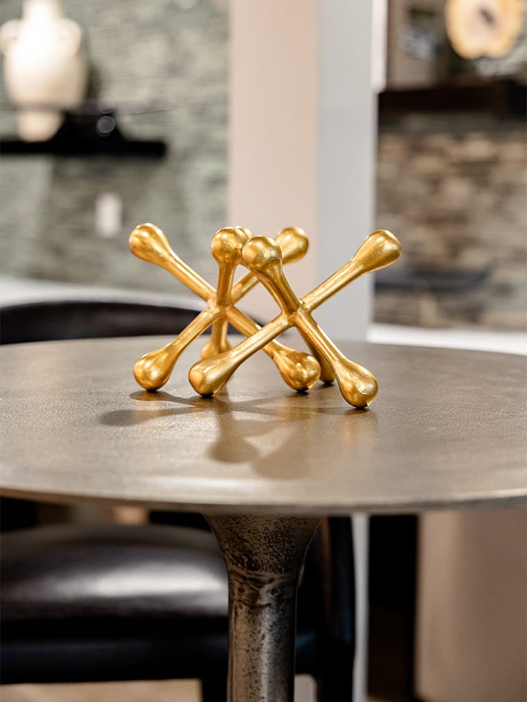 Stylish gold bone centerpiece on modern round table for contemporary home decor.