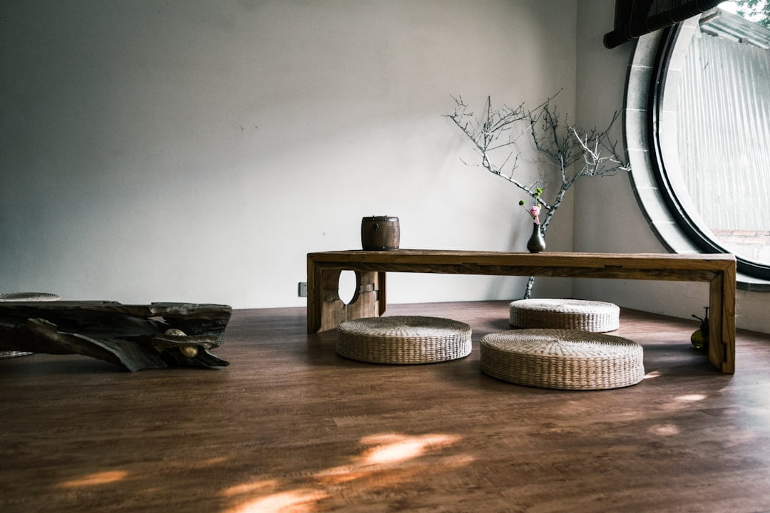 Minimalist interior design featuring a wooden table and natural light in a serene setting.