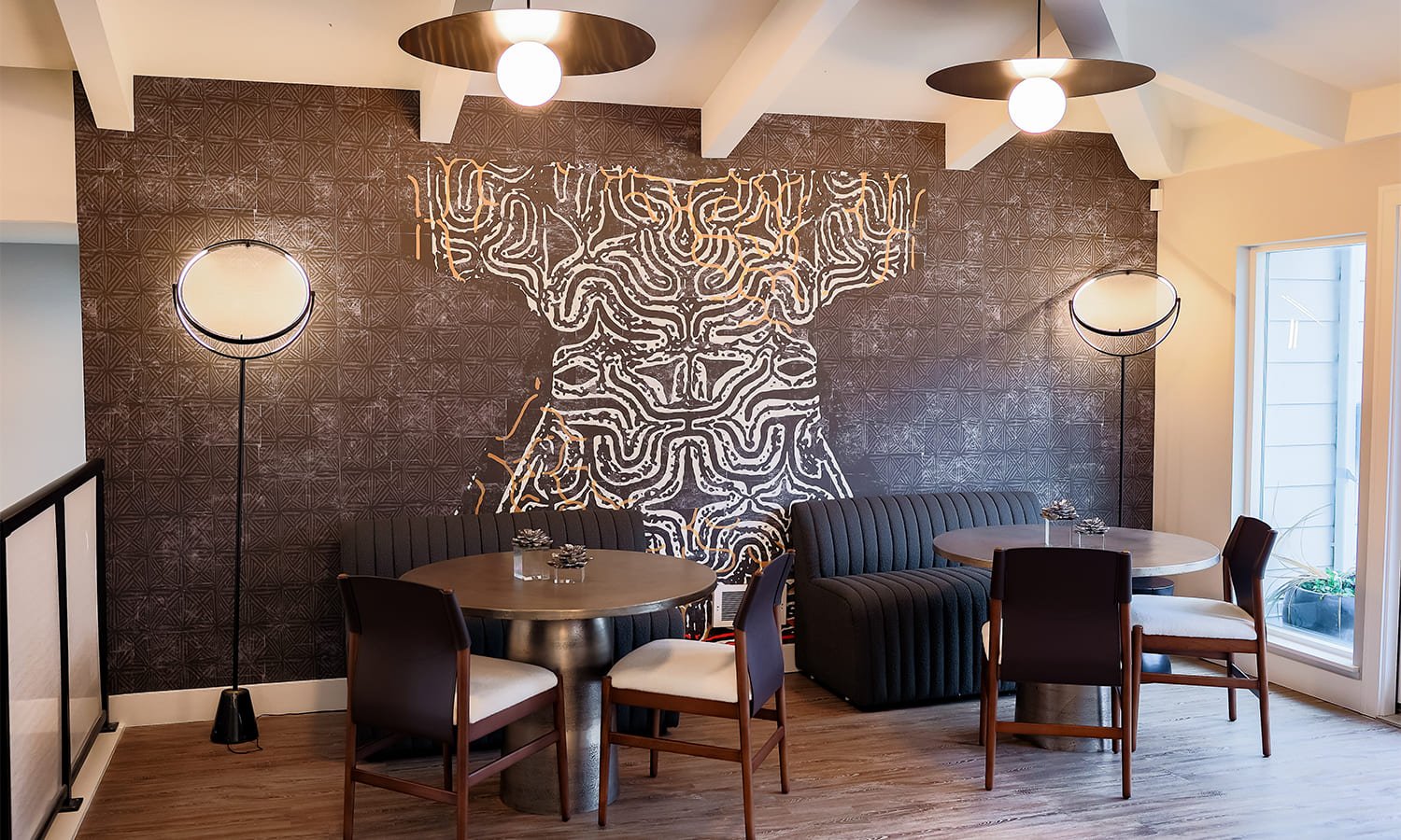 Contemporary dining area featuring an abstract cow mural and inviting furnishings for a stylish atmosphere.