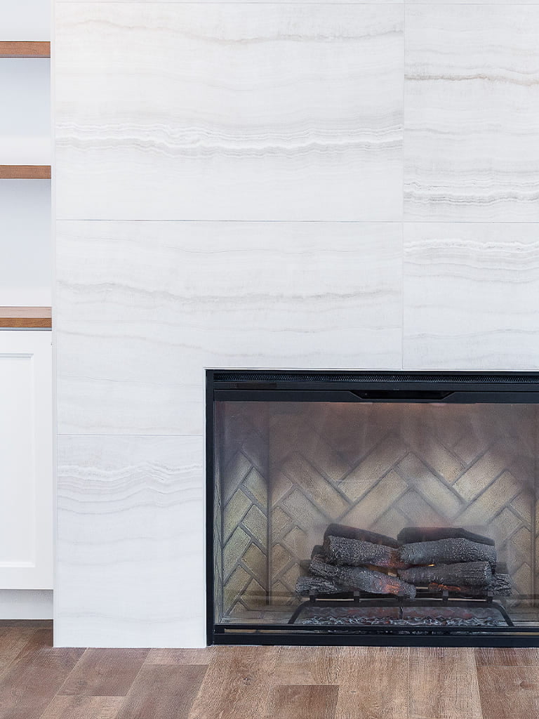 Stylish modern living room featuring a sleek fireplace and elegant stone wall design.