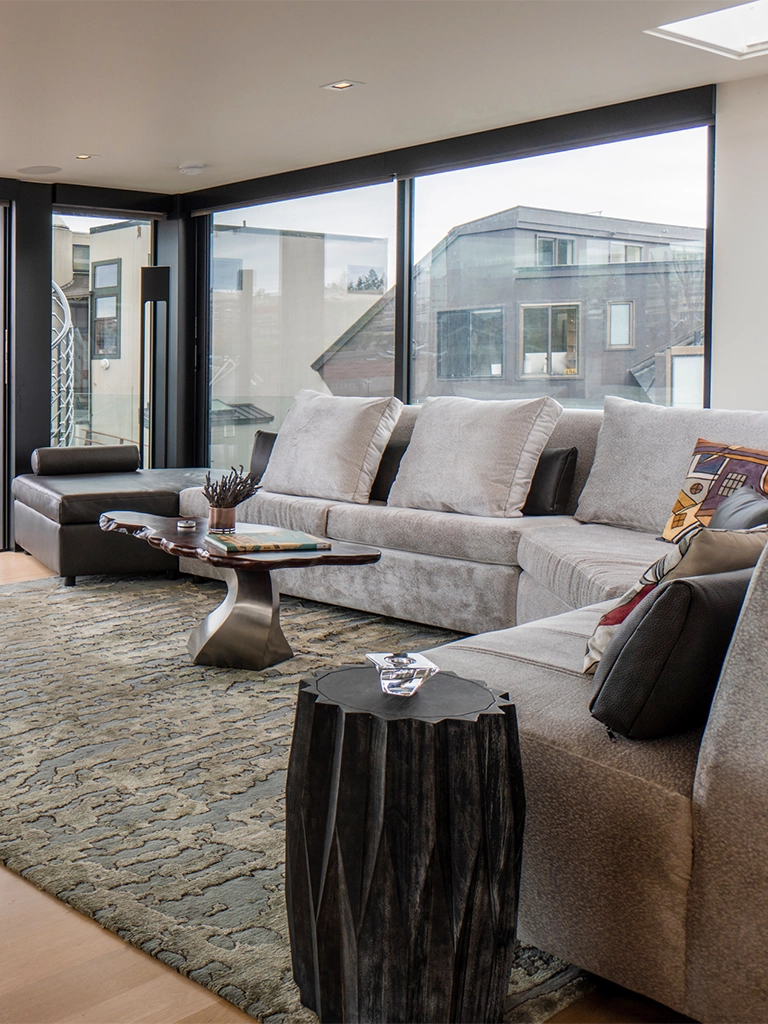 Elegant modern living room with light gray sofa and panoramic urban views.