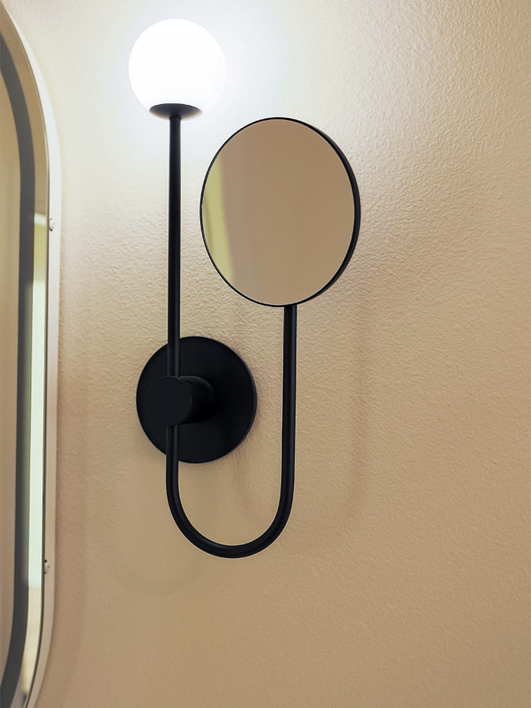 Contemporary wall-mounted light and mirror fixture with sleek design and warm illumination.