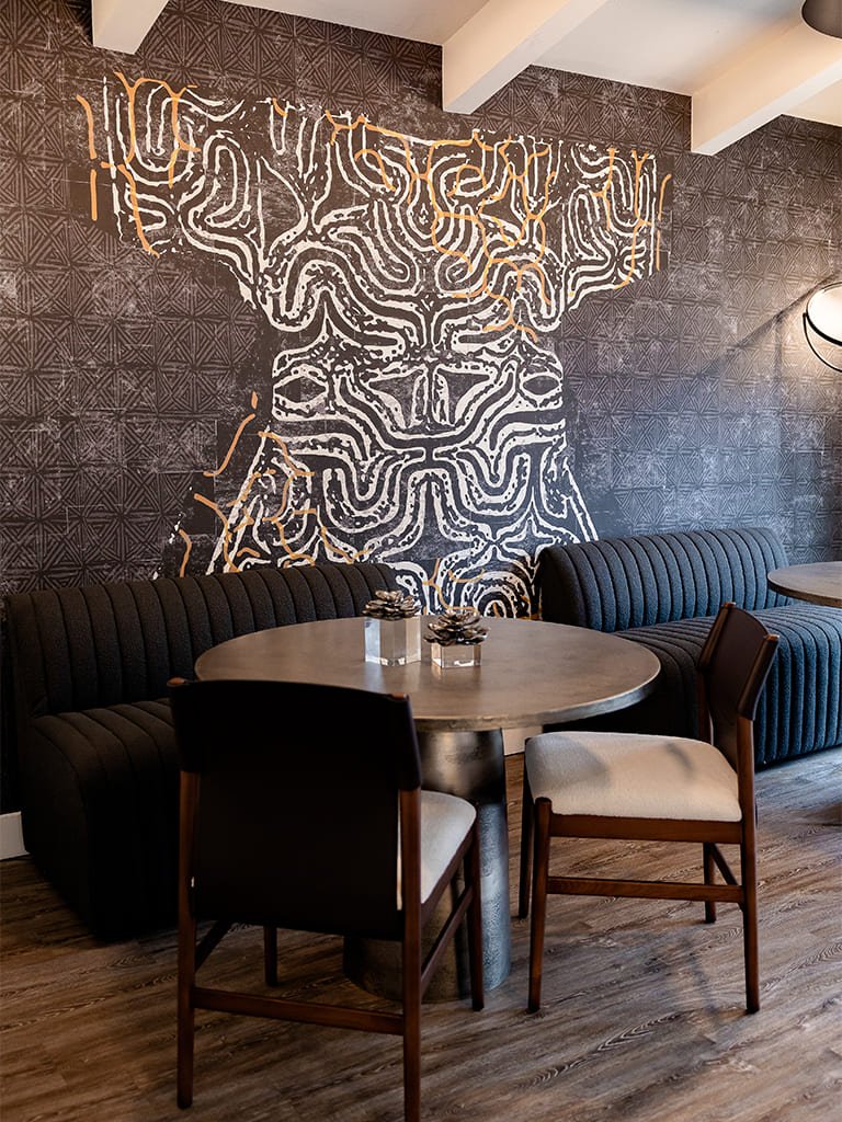 Contemporary dining area featuring an elegant abstract mural and stylish furniture for social gatherings.