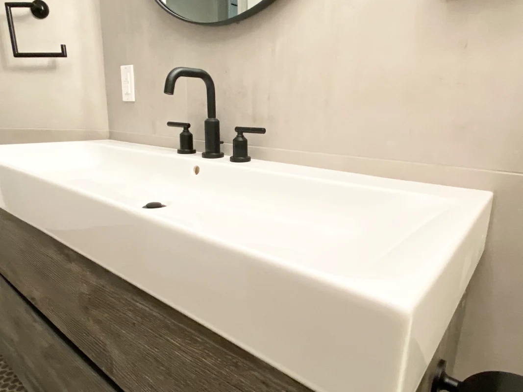 Elegant modern bathroom sink design featuring a sleek white finish and stylish black accents.