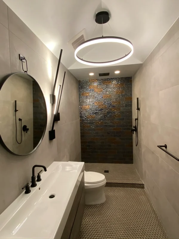 Elegant modern bathroom featuring minimalist design, circular mirror, and textured shower wall.