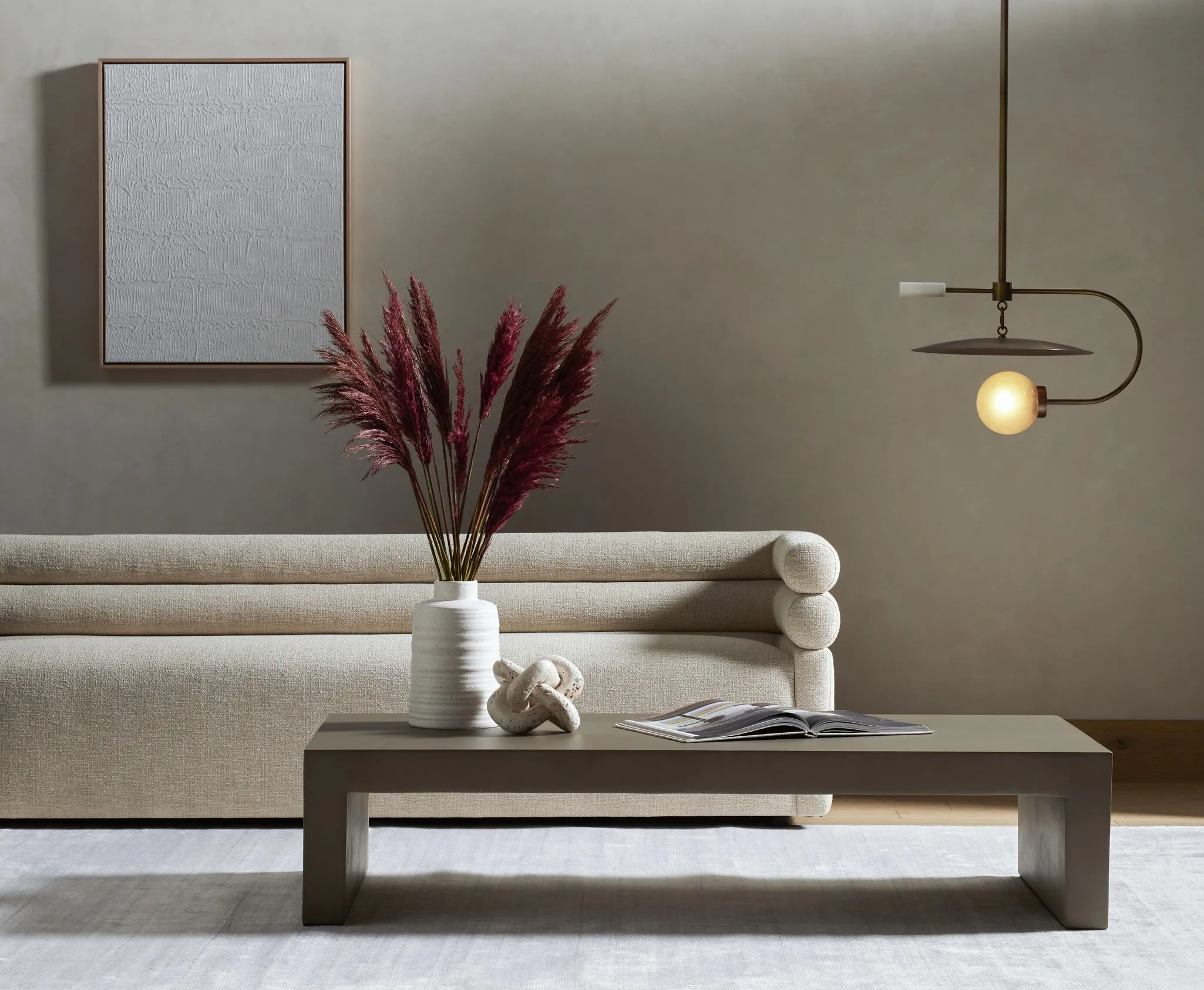 Chic minimalist living room featuring a plush sofa and pampas grass decor.