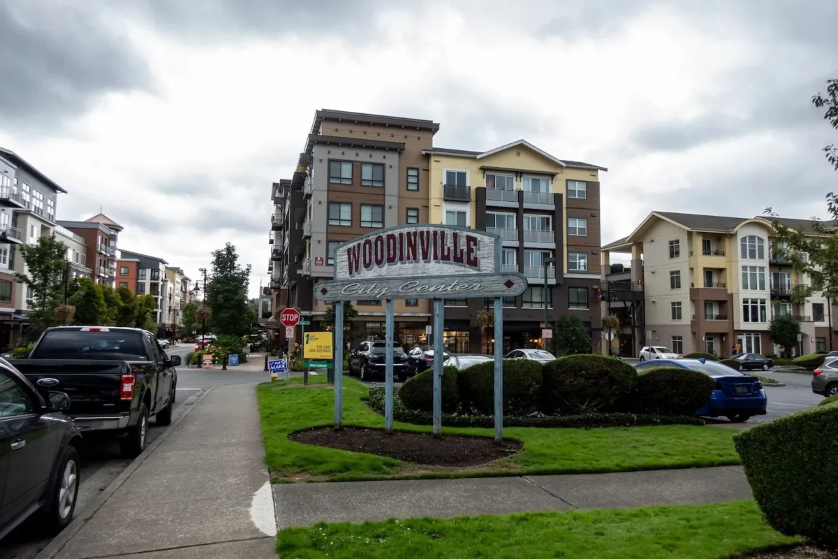 Woodinville City Center sign in a vibrant urban setting with greenery and modern buildings.