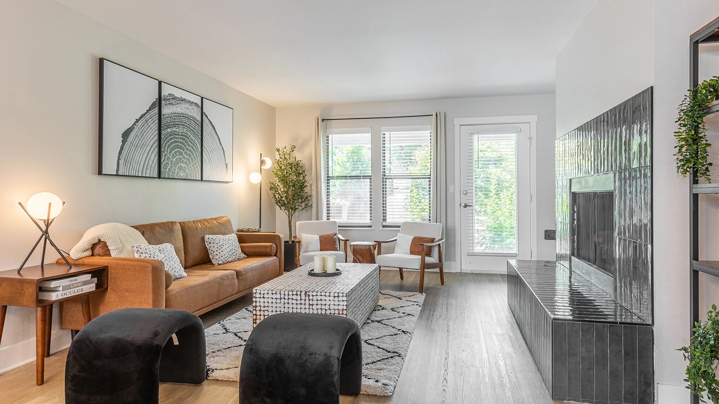 Cozy modern living room with a leather sofa, stylish decor, and natural light.