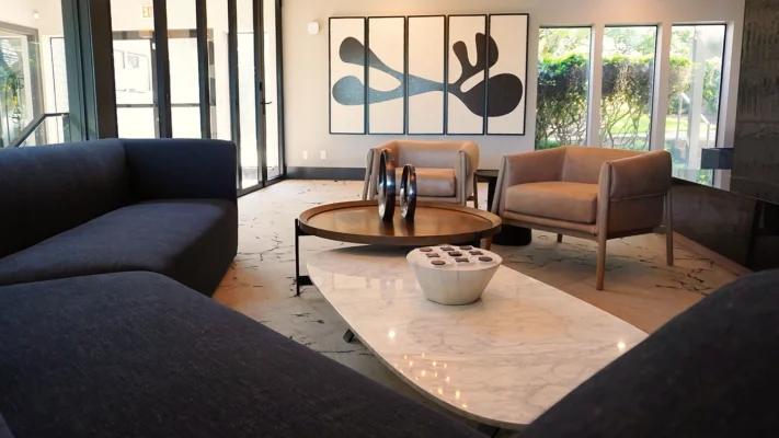 Modern lounge area featuring a stylish navy sectional sofa and elegant marble coffee table.