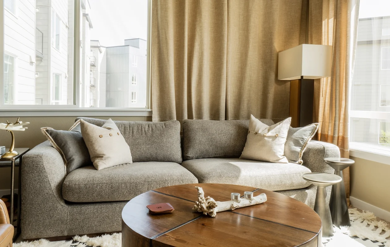 Modern cozy urban living room with plush sofa, stylish decor, and abundant natural light.