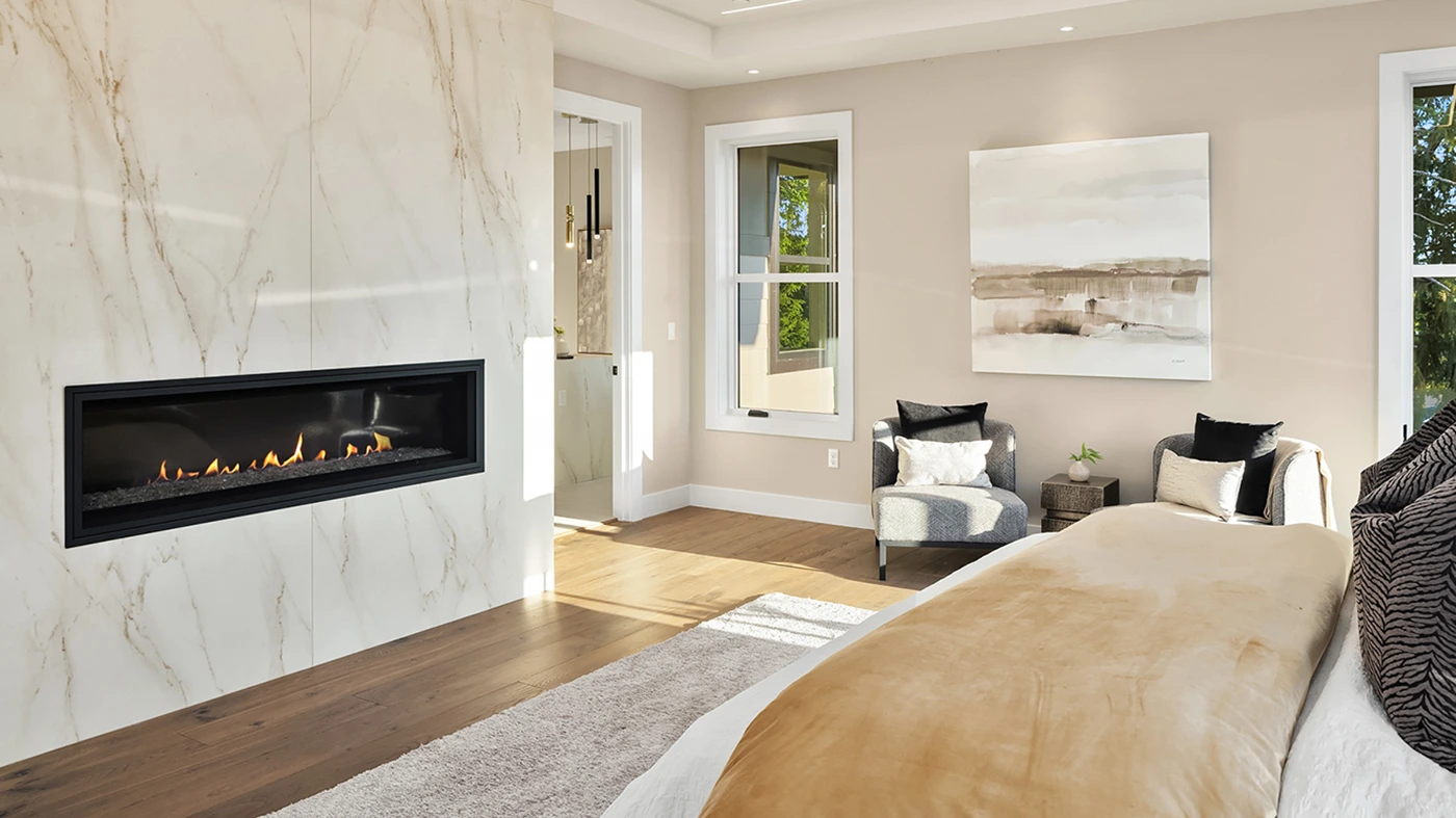 Modern elegant bedroom design featuring a marble fireplace, hardwood flooring, and serene decor.