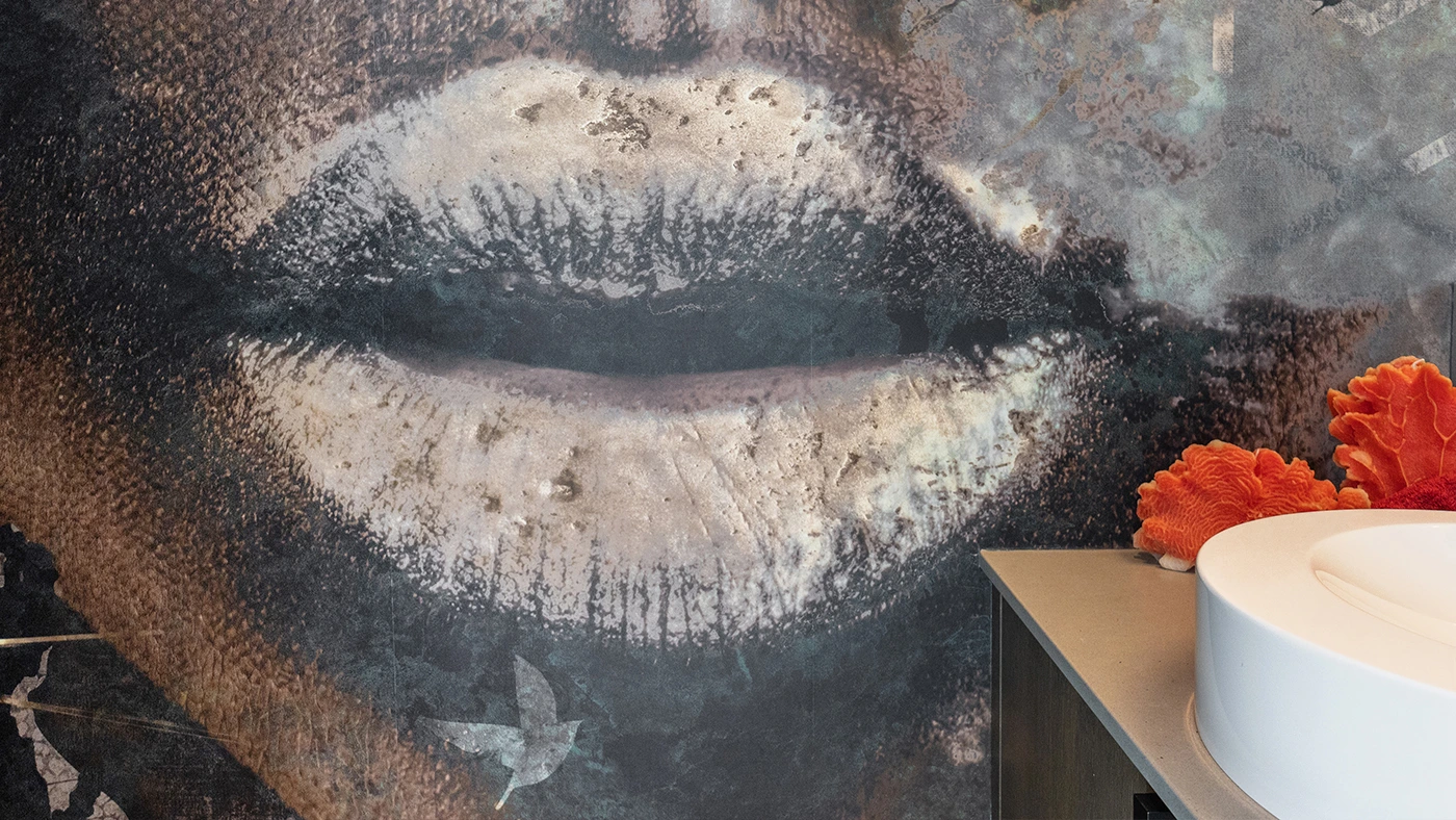 Artistic lips mural with modern sink, blending creativity and design in a stylish bathroom.