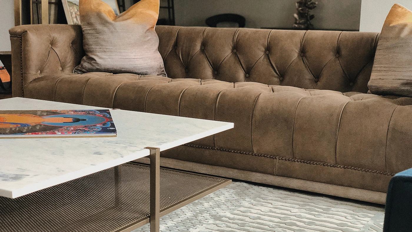 Stylish living room with a brown tufted couch, modern coffee table, and cozy decor.