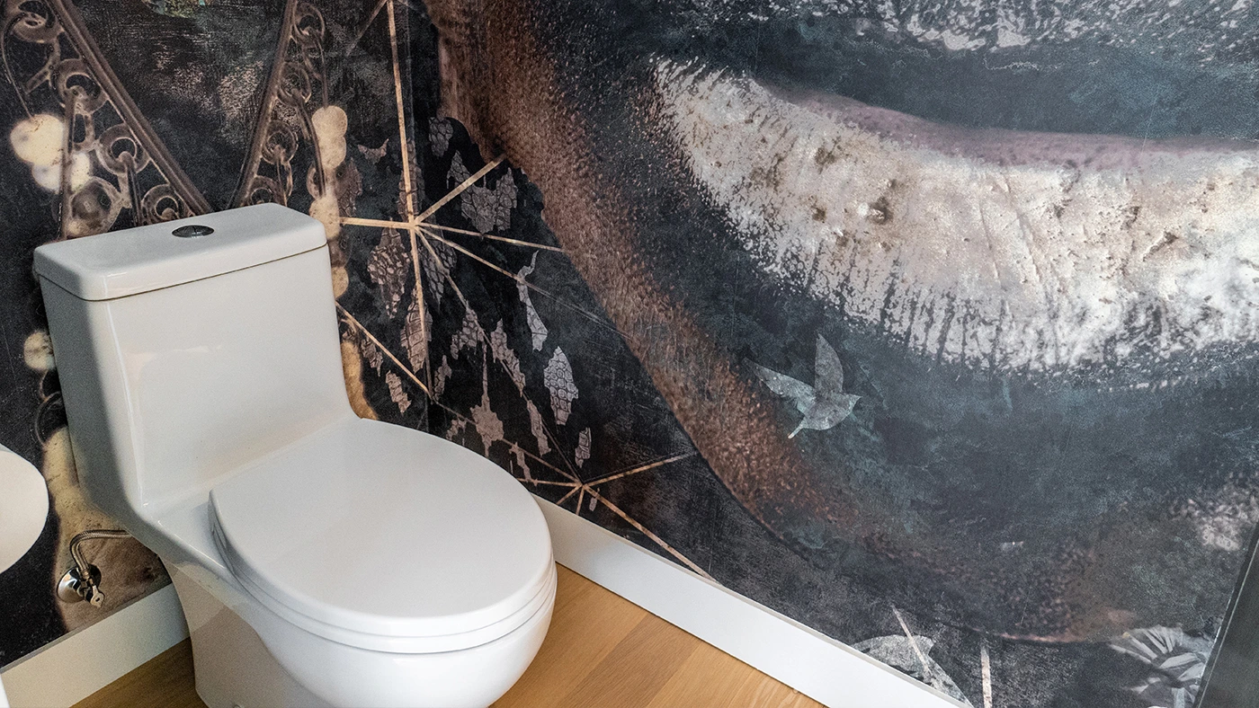 Modern bathroom with artistic wall mural and sleek toilet design creates a unique space.