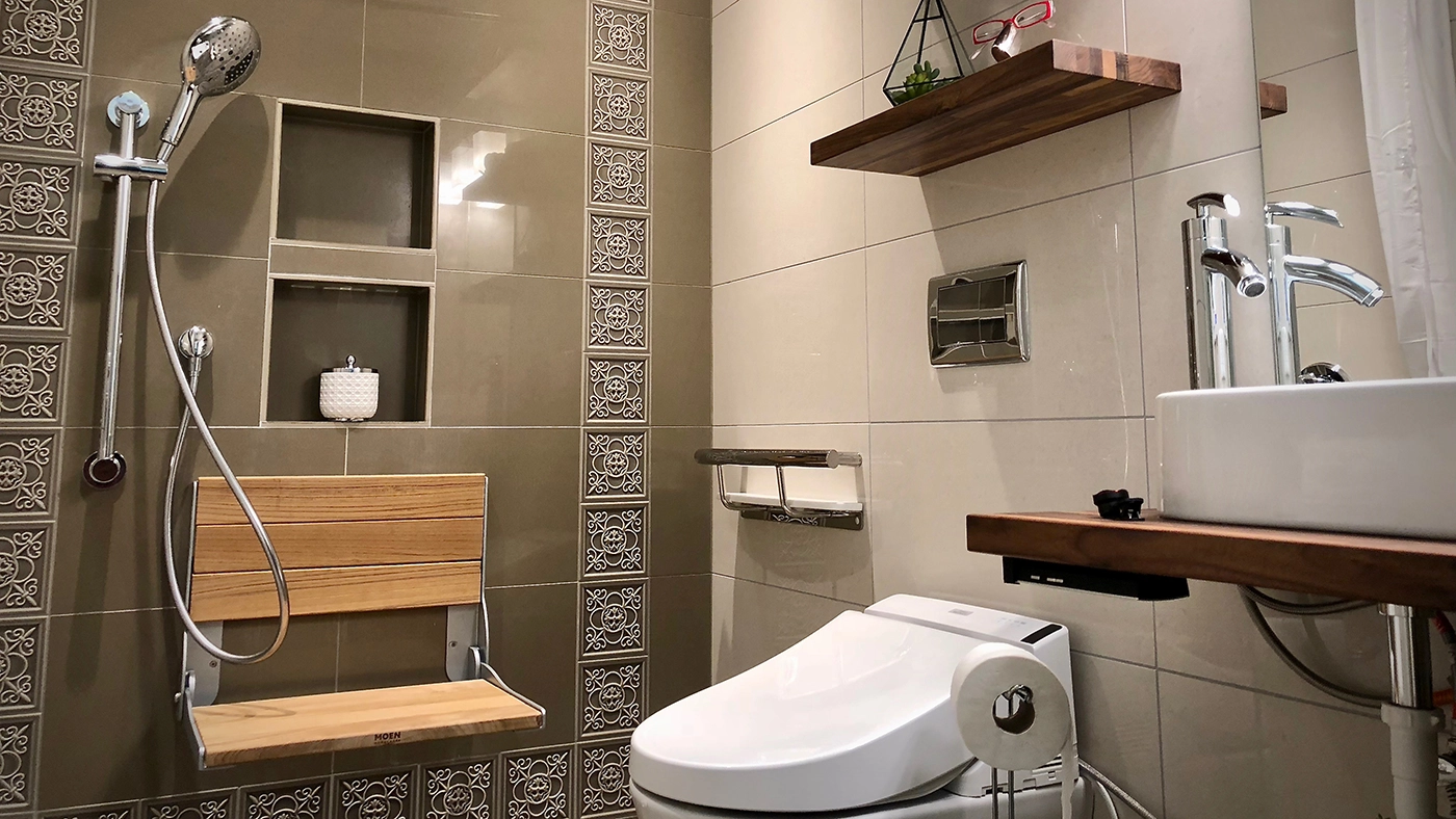 Modern bathroom design featuring stylish tiles, a shower area, and minimalist decor for enhanced comfort.