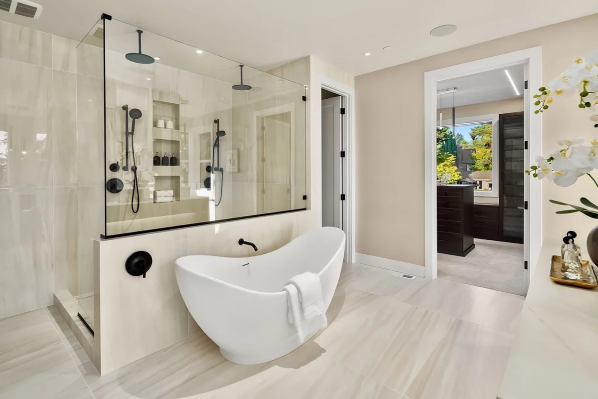 Elegant modern bathroom with freestanding tub, glass shower, and luxurious marble finishes.