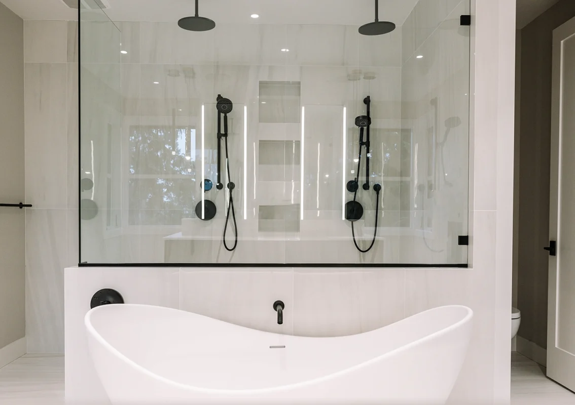 Sleek modern bathroom featuring a freestanding tub, glass shower, and minimalist design elements.