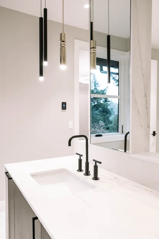 Sleek modern bathroom featuring gray textures, white marble, and stylish matte black fixtures.