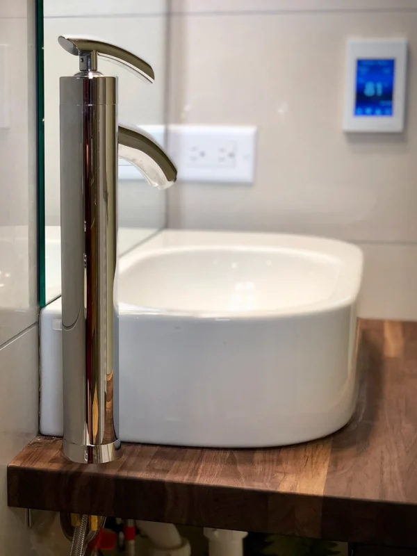 Elegant modern bathroom with a stylish vessel sink and chrome faucet on a wooden countertop.