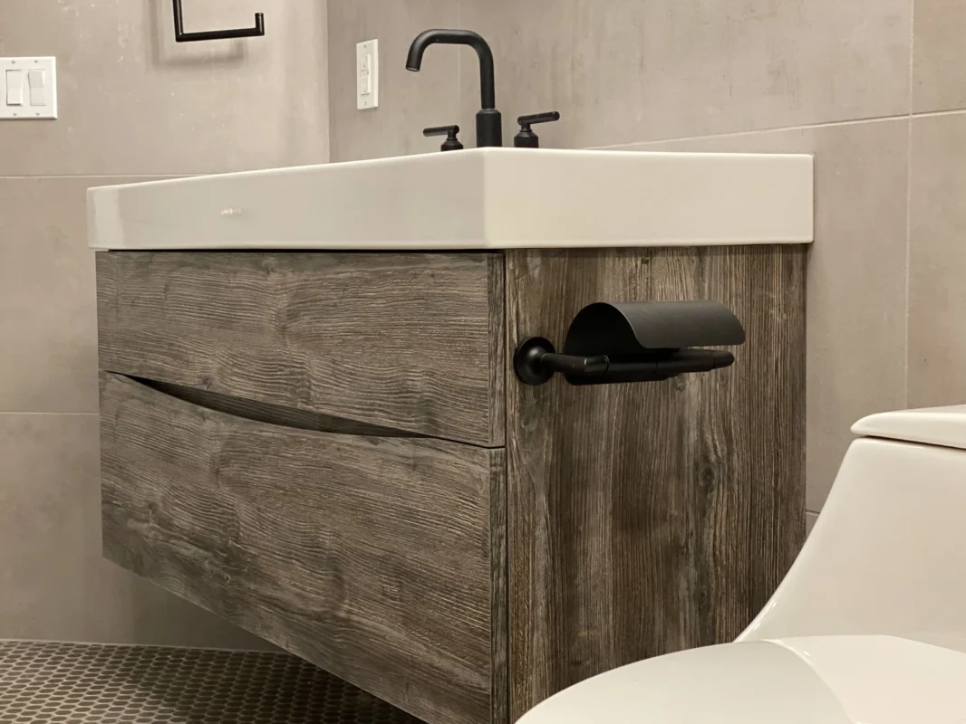 Modern bathroom vanity with sleek wood design and contemporary toilet for stylish functionality.