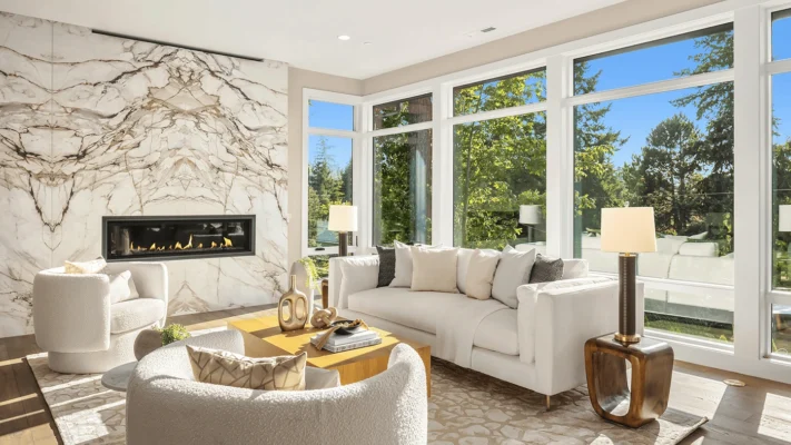 Stylish modern living room featuring marble accents, plush seating, and large windows with nature views.