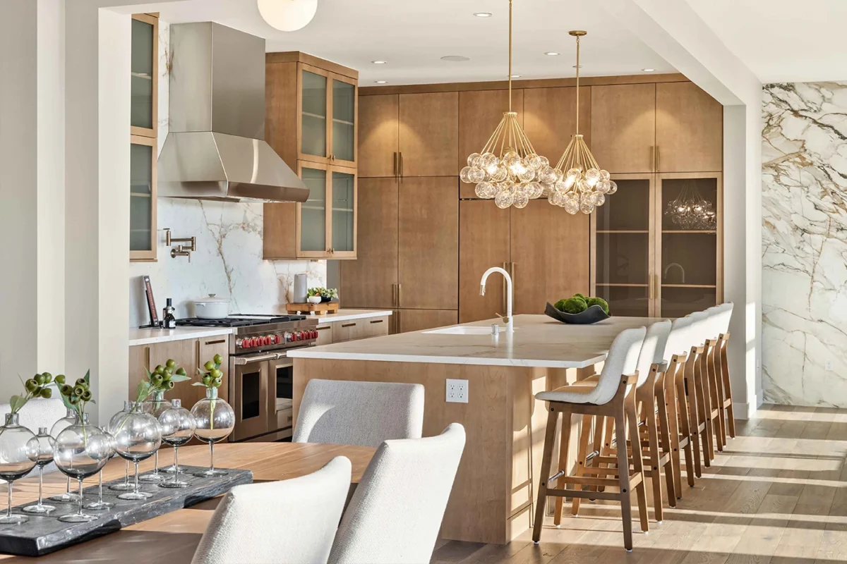 Elegant modern kitchen design with a spacious island, high stools, and luxurious marble accents.