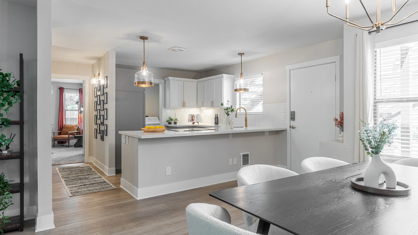 Modern kitchen and dining area featuring minimalist design, natural light, and cozy decor.