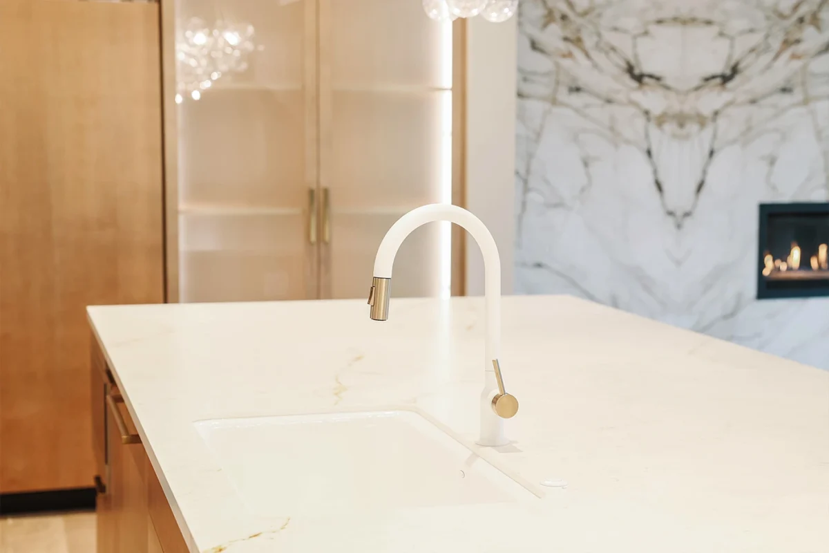 Sleek modern kitchen with minimalist design, featuring a white countertop and stylish gold accents.