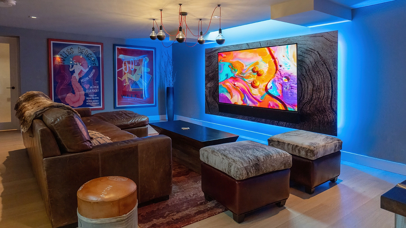 Stylish modern living room with vibrant artwork, leather sofa, and industrial lighting accents.