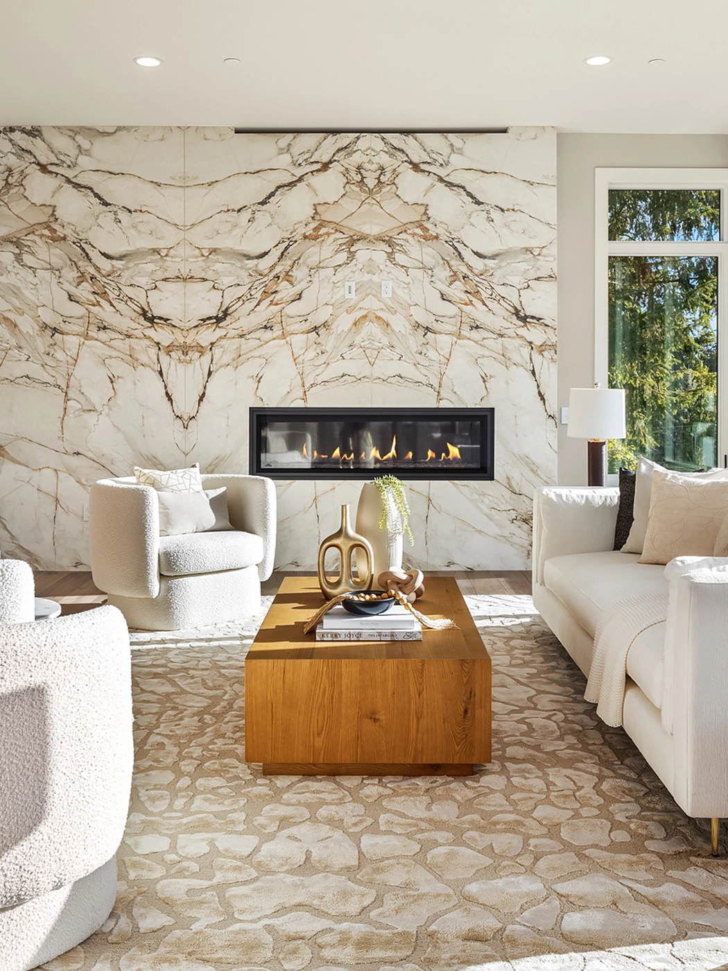 Elegant modern living room with marble feature wall, contemporary furniture, and abundant natural light.